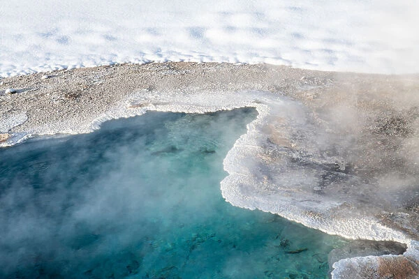 Bright blue thermal feature in snow, Yellowstone National Park