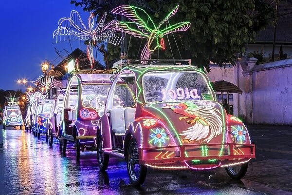 Brightly coloured illuminated pedal cars in Yogyakarta city, Java, Indonesia, Southeast Asia