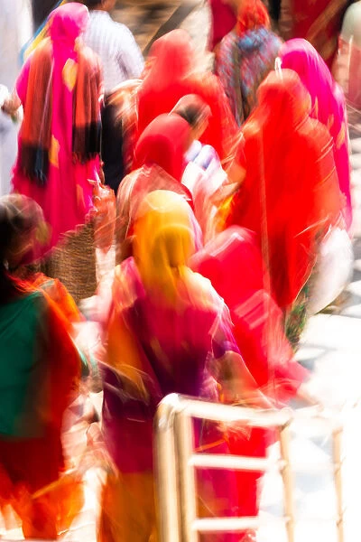 Brightly coloured saris (clothing) and veils, blurred in motion for effect