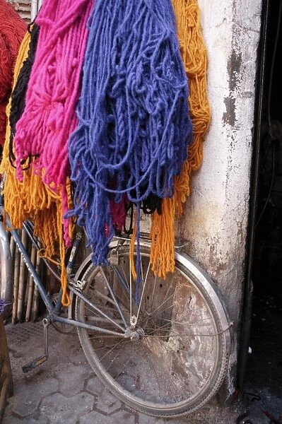 Brightly dyed wool hanging over bicycle
