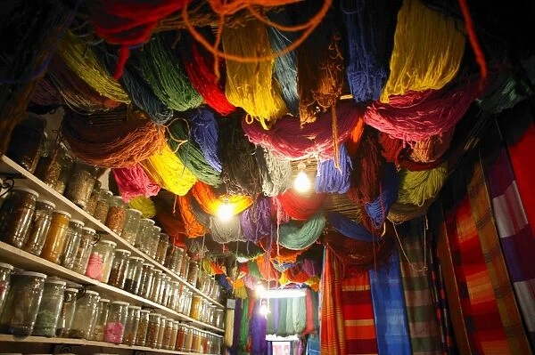 Brightly dyed wool hanging from roof of a shop