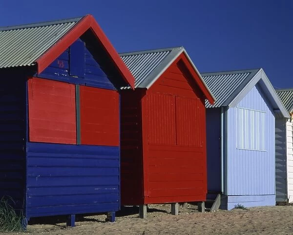 Brightly painted red and blue wooden beach bathing huts, Brighton Beach