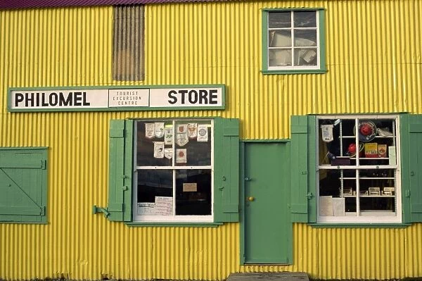 Brightly painted yellow corrugated wall and green wooden building of the general store selling hardware and gifts, Stanley, Falkland Islands