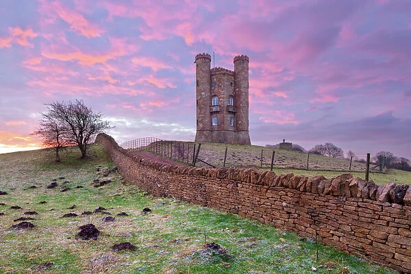 Broadway Tower and Cotswold drystone wall at sunrise, Broadway, Cotswolds, Worcestershire