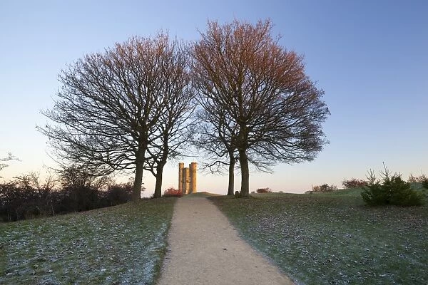 Broadway Tower framed by trees in winter frost at sunrise, Broadway, Cotswolds, Worcestershire