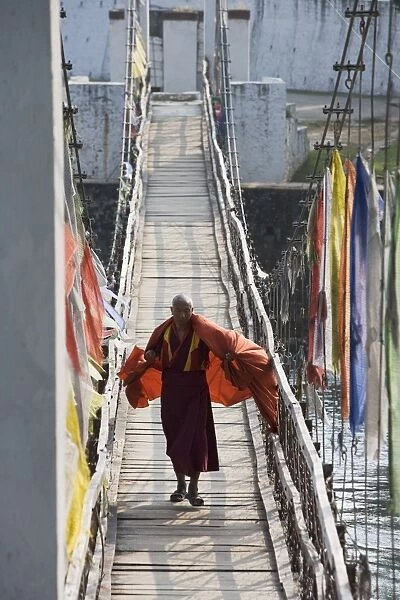 Buddhist Monk crossing bridge to Punakha Dzong, Punakha, Bhutan, Asia