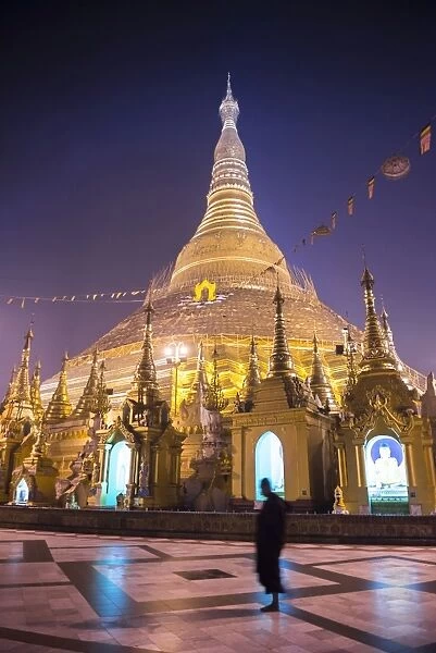 Buddhist monk at Shwedagon Pagoda (Shwedagon Zedi Daw) (Golden Pagoda) at night, Yangon (Rangoon)