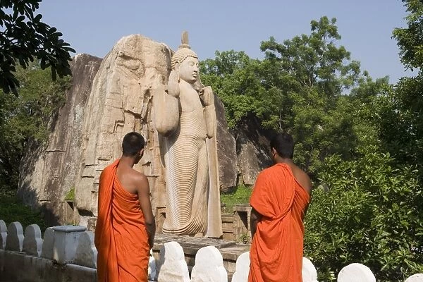 Buddhist monks in front of the giant standing statue