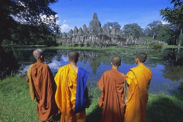 Buddhist monks standing in front of the Bayon temple, Angkor, UNESCO World Heritage Site