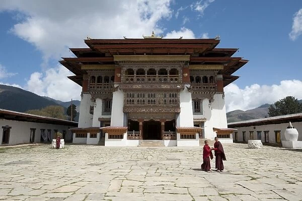 Buddhist monks in stone courtyard of Gangtey dzong (monastery), the largest Nyingmapa