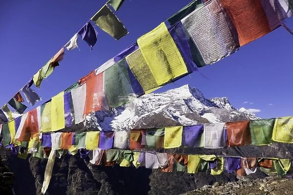 Buddhist prayer flags with Mount Kongde Ri behind taken just above the town of Namche Bazaar, Himalayas, Nepal, Asia