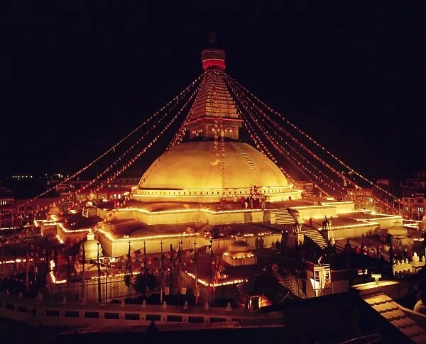 Buddhist stupa lit by candles at night