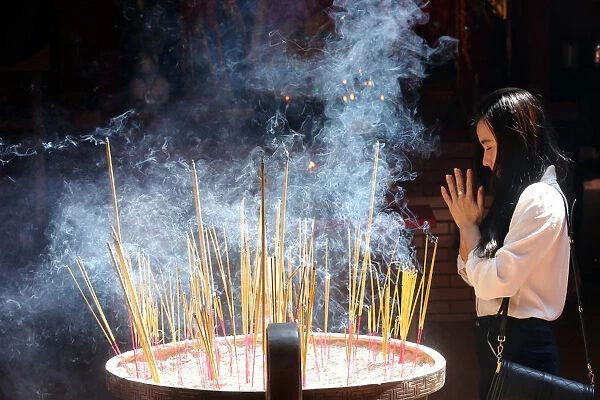 Buddhist worshipper burning incense sticks, Chua On Lang Taoist Temple, Ho Chi Minh City