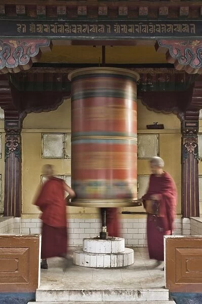 Buddhists turning prayer wheel