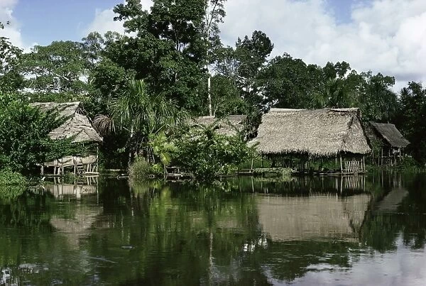 Building on stilts reflected in the River Amazon