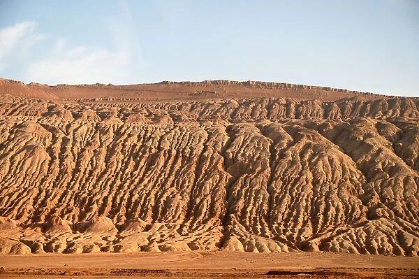 Buildings dwarfed by vast Gobi desert landscape along the Silk Road near Turfan, Xinjiang