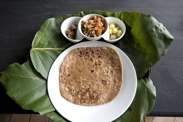 Burmese lunch of chapati with beef curry, vegetables and potatoes, served on teak leaf mat