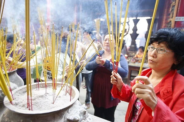 Burning incense during Tet, the Vietnamese lunar New Year celebration, Thien Hau Temple