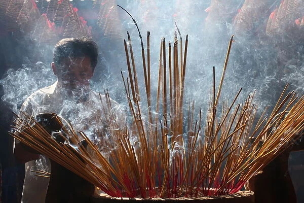 Burning incense during Tet, the Vietnamese lunar New Year celebration, Quan Am Pagoda