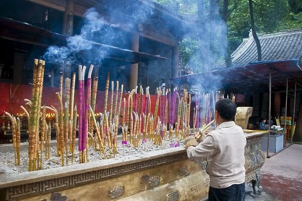 Burning sticks of Tibetan incense in a monastery above the giant Buddha of Leshan