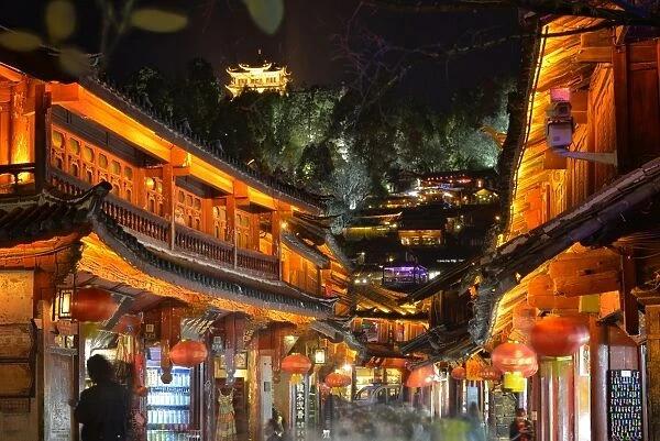Busy Lijiang Old Town, UNESCO World Heritage Site, at night with Lion Hill and Wan Gu Tower, Lijiang, Yunnan, China, Asia