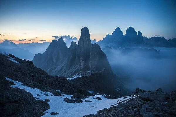 The Cadini di Misurina emerging from the fog after sunset, in a typical Dolomitic landscape, Dolomites, South Tyrol, Italy, Europe