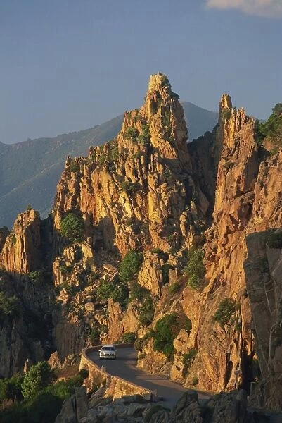 The Calanche, white granite rocks, with car on road below, near Piana, Corsica