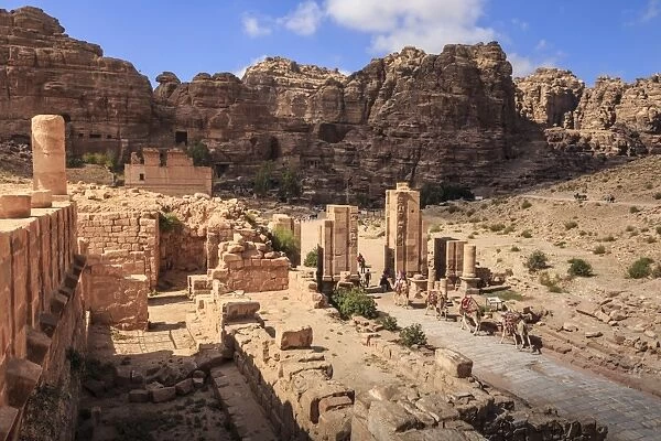 Camel train approaches Temenos Gateway with Qasr al-Bint temple, City of Petra ruins