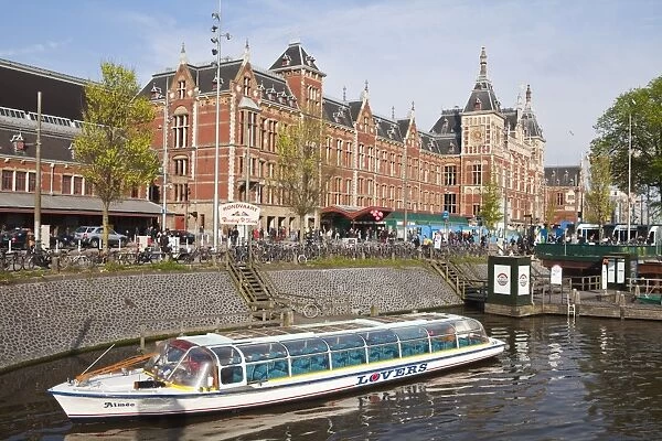 Canal tour boat outside Centraal Station, the central train station, Amsterdam