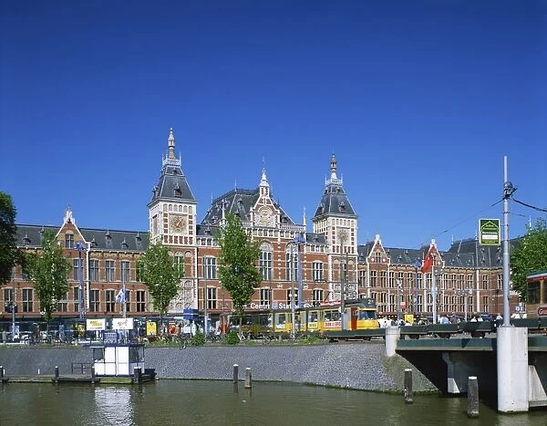 The Canal and tram in front of the Central Station in Amsterdam, Holland, Europe
