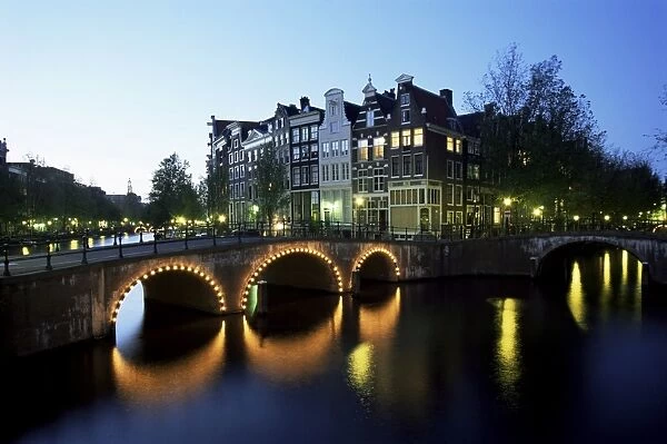 Canals, illuminated bridges and traditional buildings at night