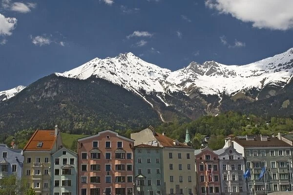 Candy coloured houses with backdrop of mountains in spring snow, Innsbruck