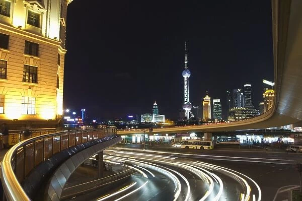 Car light trails on the Bund and The Oriental Pearl Tower illuminated in Pudong new area
