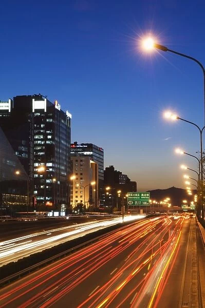 Car light trails and modern architecture on a city ring road, Beijing, China, Asia