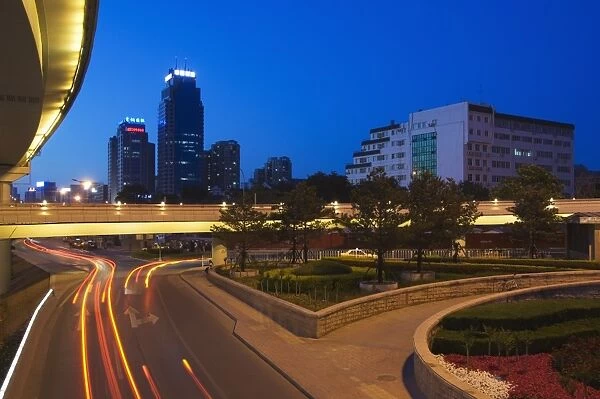 Car light trails and modern buildings near Beijing North Train Station