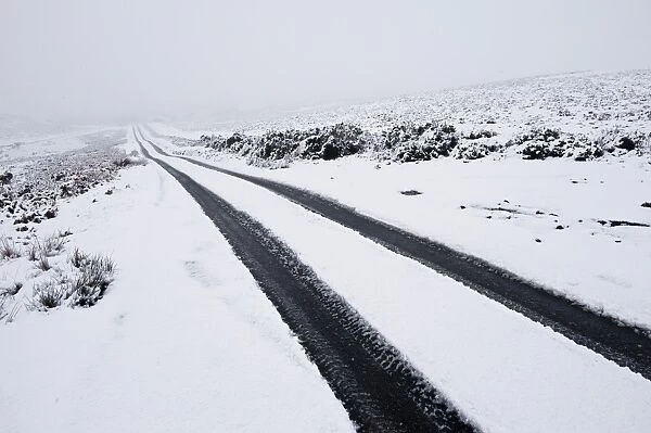 Car tyre tracks on a snowy road on the Mynydd Epynt moorland, Powys, Wales, United Kingdom