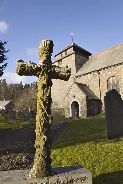 Carved stone cross headstone in front of the 14th century St