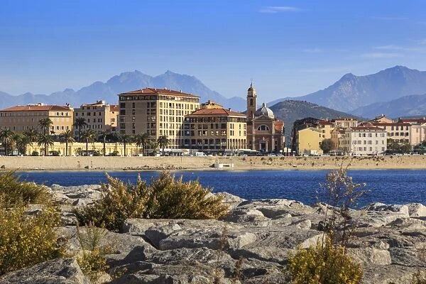 Cathedral, city and hazy mountains, from its rocky waterfont, Ajaccio, Island of Corsica