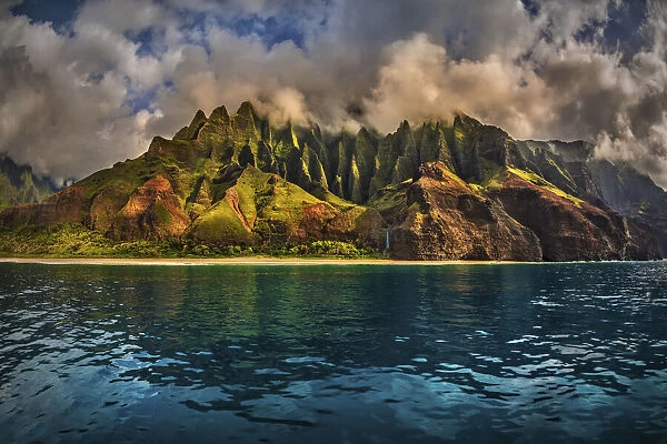 The Cathedral of the NaPali Coastline towers over the calm summer waters at sunset