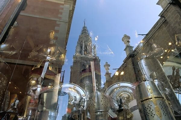 Cathedral reflected in window of shop selling medieval armour