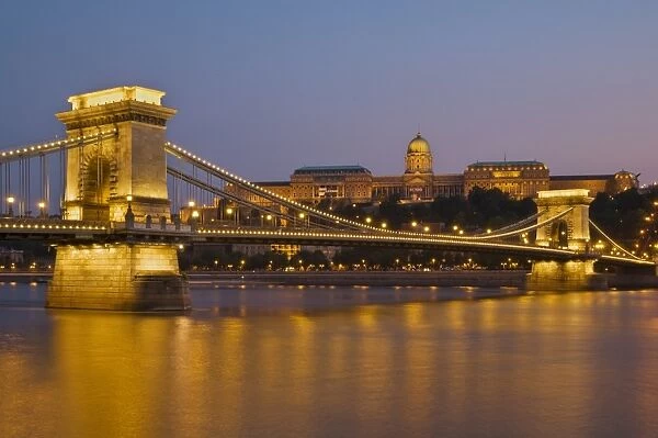 The Chain Bridge (Szechenyi Lanchid), over the River Danube, illuminated at sunset with the Hungarian National Gallery behind, UNESCO World Heritage Site, Budapest