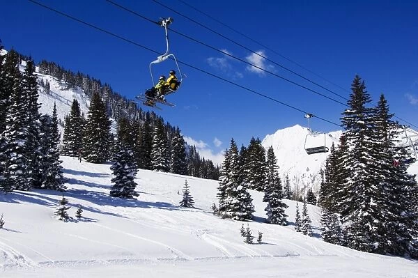 A chair lift carries skiers at Alta