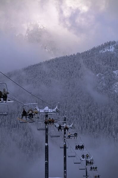Chair lift filled with skiers and snowboarders