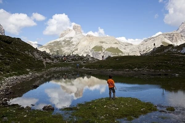 Child playing on an alpine pond, Dolomites, eastern Alps, Belluno province, Italy, Europe