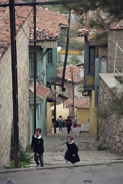 Children climb steps in a narrow street in the town of Bursa