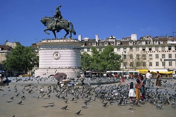 Children feed pigeons in Figueira Square in Lisbon