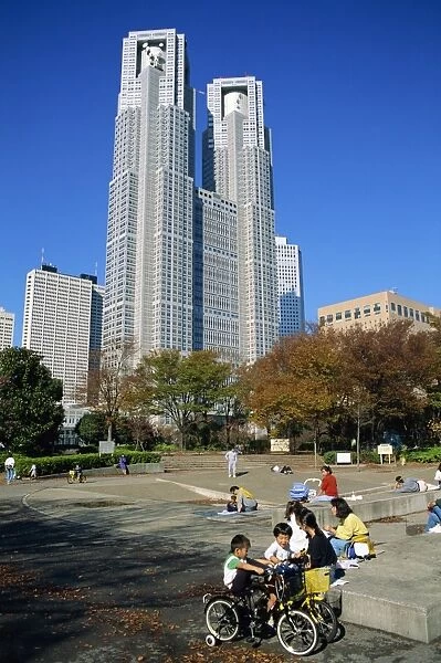 Children play in a park below the New Tokyo City Hall in Shinjuku