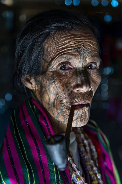 Chin woman with spiderweb tattoo smoking a pipe, Mindat, Chin state, Myanmar (Burma)