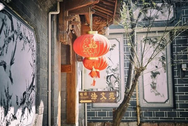 Chinese lanterns and wall paintings in an alley of Lijiangs Old Town, UNESCO World Heritage Site, Lijiang, Yunnan, China, Asia