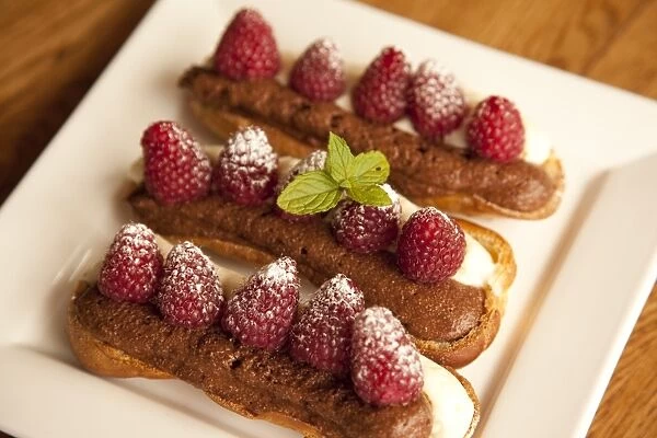 Chocolate eclairs topped with raspberries, French cafe, France, Europe